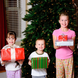 Children with presents in front of Christmas tree